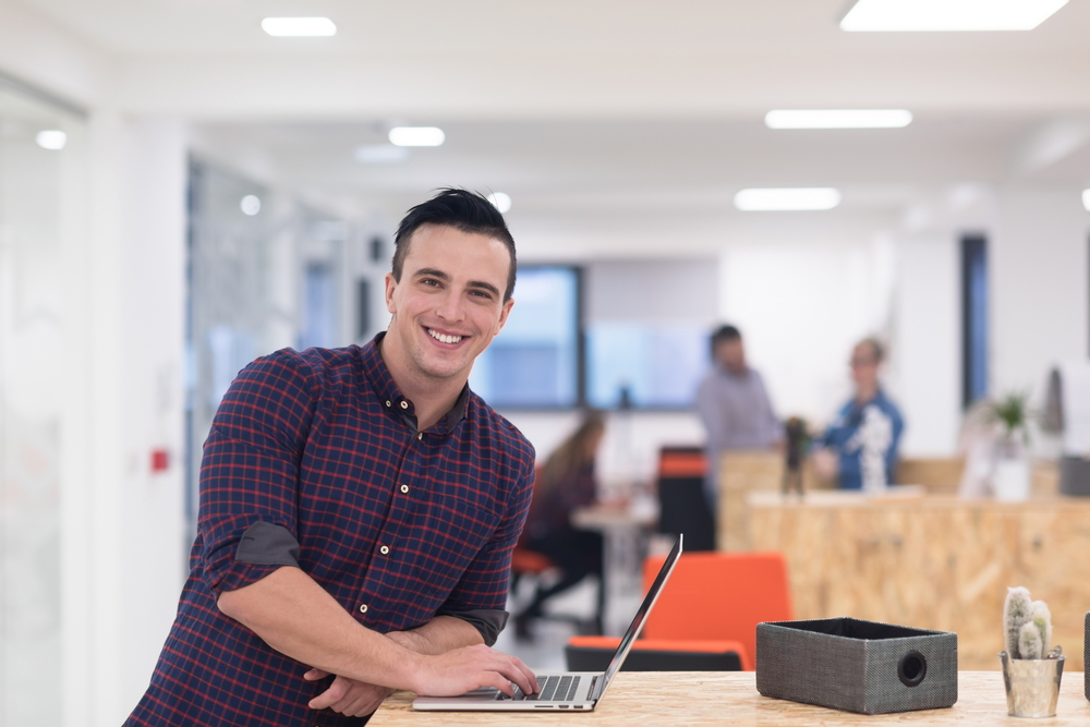 portrait of young businessman in casual clothes at modern startup business office space, working on laptop computer portrait of young businessman in casual clothes at modern startup business office space, working on laptop computer